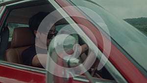 Brutal tomboy girl sitting in a vintage red car