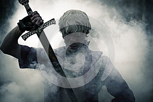 Brutal warrior with sword in smoke photo
