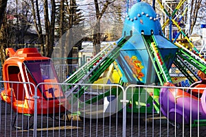 Bryansk, Russia - April 2022: a children`s attraction in the form of a carousel with booths in the form of a red helicopter, cars,