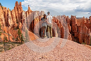 Bryce Canyon - Hugging couple with scenic aerial view of hoodoo sandstone rock formations on Queens Garden trail, Utah, USA