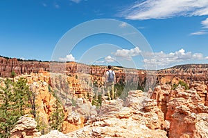 Bryce Canyon - Man with scenic aerial view of hoodoo sandstone rock formations on Peekaboo trail in Utah, USA