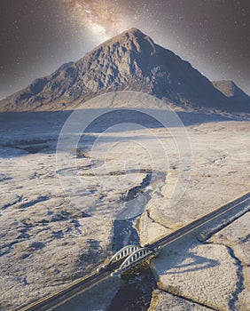 Buachaille Etive Mor aerial view at night during winter frost moor with stars in sky highlands landscape and A82 road bridge at Gl