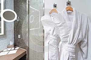 Bubble bath time : Clean White bathrobes on hanger in a bathroom. How to Keep Your Bathrobe Clean and Fluffy. - Always Spot Test.