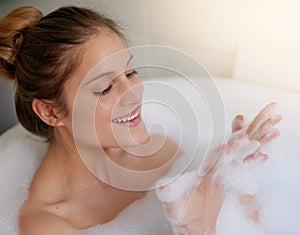 Bubble baths are the best kind of stress reliever. a beautiful young woman relaxing in the bathtub.