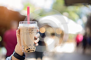 Bubble milk Tea in glass in women hand