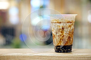 Bubble Milk Tea - A plastic glass of fresh milk with black sugar syrup Kuromitsu and hot black pearl Boba topped with cream