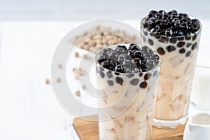 Bubble milk tea with tapioca pearl topping ingredient, famous Taiwanese drink on white wooden table