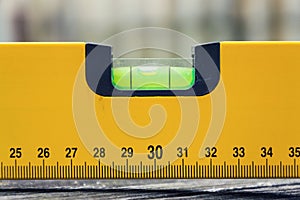 Bubble spirit water level construction tool on wooden board closeup