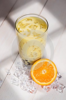 Bubble tea. Homemade Orange Milk Tea with Pearls on wooden table