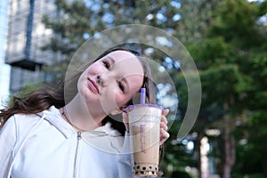 bubble tee Cheerful kid showing like gesture and holding milkshake isolated, banner