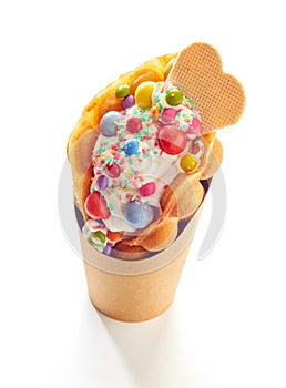 Bubble waffle ice cream with colorful candies isolated on a white background