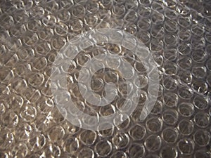 Bubble wrap is a pliable transparent plastic material used for packing fragile items. Regularly spaced, protruding air-filled