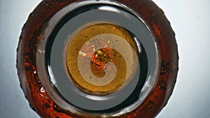 Bubbled craft swishing flask closeup. Overflowing beer waving splashing bottle