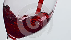 Bubbled red wine beverage closeup. Fresh alcoholic liquid swashing wineglass