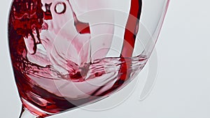 Bubbled red wine beverage closeup. Fresh alcoholic liquid swashing wineglass