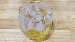 The bubbles created by mixing liquor and soda in a clear glass waft on the table, ready to refresh