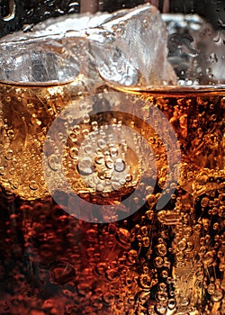 Bubbles in the glass of cola with ice.