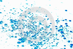 Bubbles of paint on white background, abstract pattern of blue ink. Random drop.