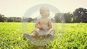 Bubbles, playing and baby in nature on grass at an outdoor park or field for fun or adventure. Childhood, cute and young