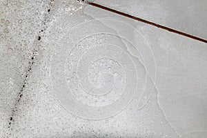 Bubbles soap detergent with scrubbing the bathroom floor dirt wet, Foam white bubble from shampoo washing on Tiled floor top view