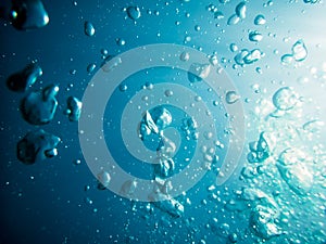 Bubbles in underwater. Sun light in blue ocean. Water texture.