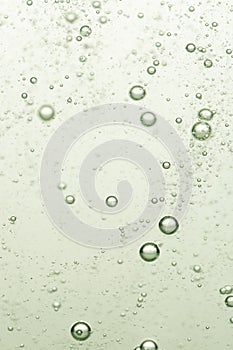 Bubbles in water on a green background. Shallow depth of field.