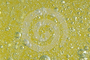 Bubbles in the water on a yellow background. Macro.