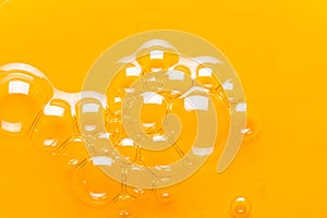 Bubbles in yellow oil. The texture of cosmetic shampoo