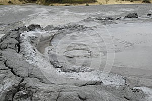 Bubbling crater of a mud volcano. Close up view onto gas bubble exploding in crater of mud volcano. Mud volcano at Paclele Mari,
