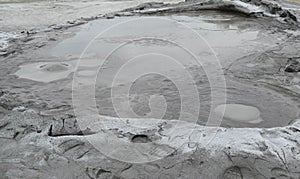 Bubbling crater of a mud volcano. Close up view onto gas bubble exploding in crater of mud volcano. Mud volcano at Paclele Mari,