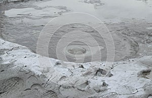 Bubbling crater of a mud volcano. Close up view onto gas bubble exploding in crater of mud volcano. Mud volcano at Paclele Mari,