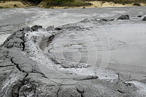 Bubbling crater of a mud volcano. Close up view onto gas bubble exploding in crater of mud volcano. Mud volcano at Paclele Mari,