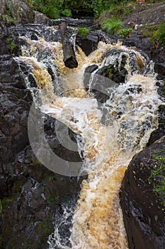 a bubbling fast cold river with cliffs and waterfalls, a mountain river