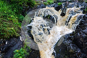 a bubbling fast cold river with cliffs and waterfalls, a mountain river