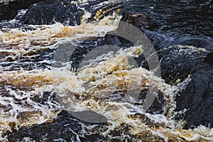 a bubbling fast cold river with cliffs and waterfalls, a mountain river
