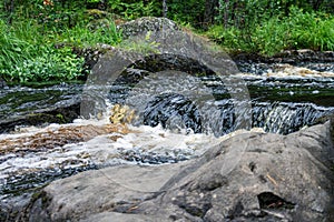a bubbling fast cold river with cliffs and waterfalls, a mountain river with rapids