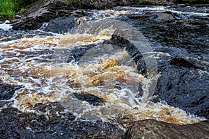 a bubbling fast cold river with cliffs and waterfalls, a mountain river with rapids