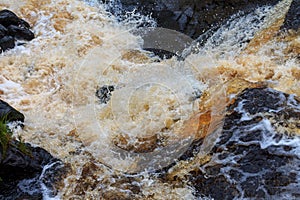 a bubbling fast cold river with cliffs and waterfalls, a mountain river with rapids