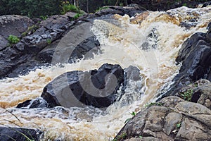 a bubbling fast cold river with cliffs and waterfalls, a mountain river with rapids