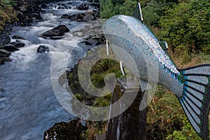 The bubbling Ketchikan Creek runs passed a sculpture of a salmon