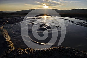 Bubbling mud. Mud volcano at sunset - landmark attraction in Buzau, Romania