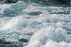 Bubbling ocean water at high tide. Turquoise sea waves foam