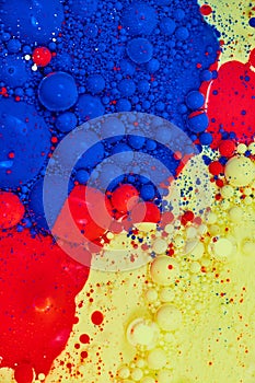 Bubbling splotches of blue red and yellow acrylic pain and oil background asset