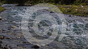 Bubbling water in a boisterous river in a mountainous area.