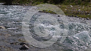 Bubbling water in a boisterous river in a mountainous area.