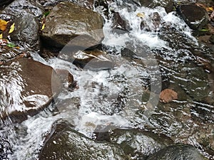 Bubbling water flow between rock in the river