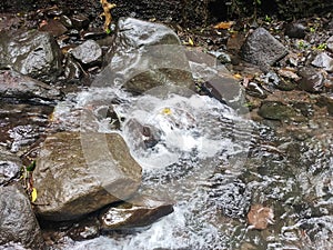 Bubbling water flow between rock in the river
