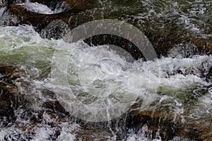 Bubbling water and stones. Falling waterfall. Background texture