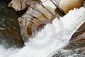 Bubbling water and stones. Falling waterfall. Background texture