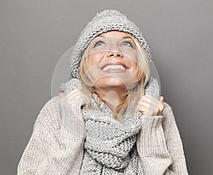 Bubbly young blonde woman smiling for warmth and cozyness in winter